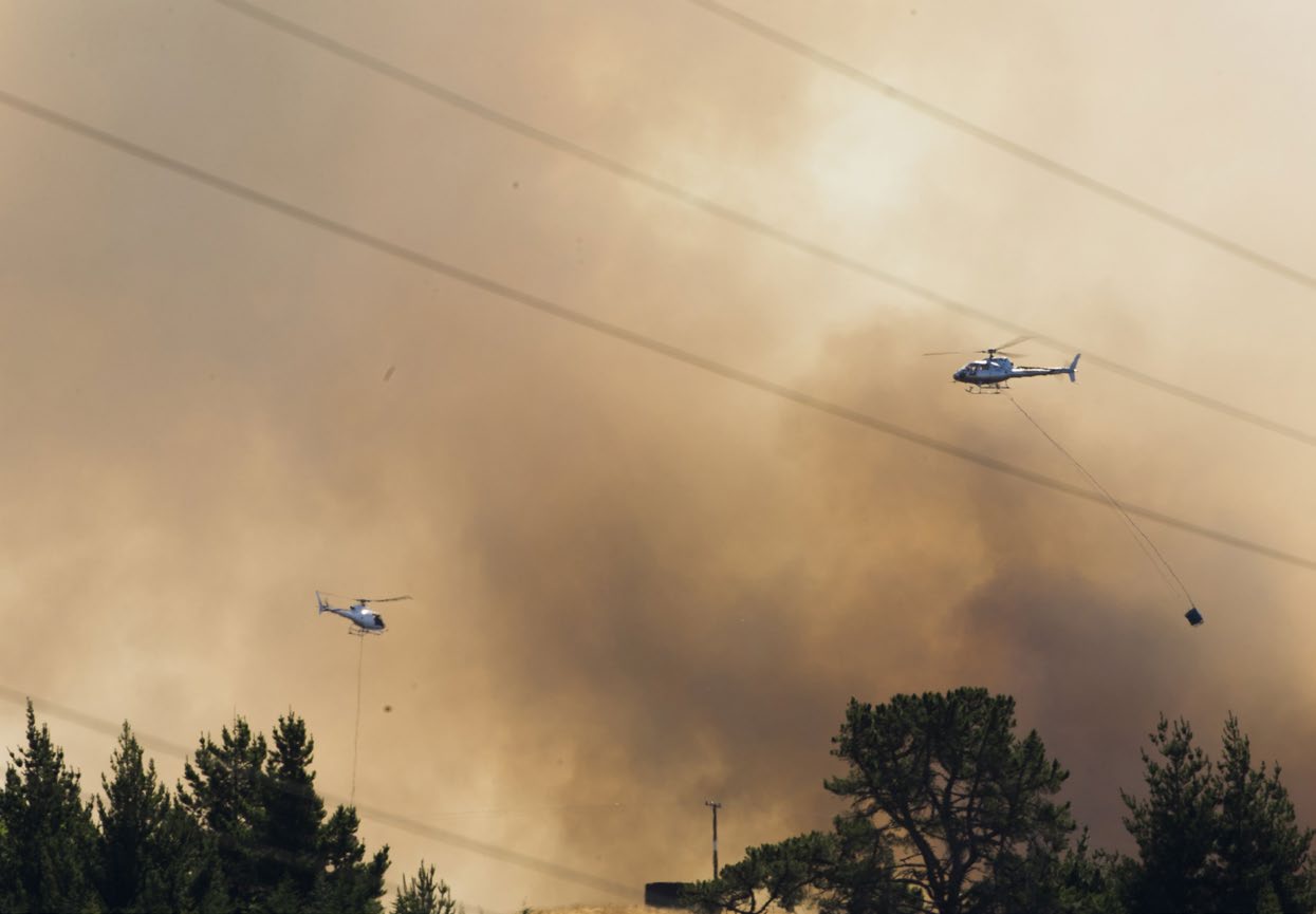 Helicopters above trees and smoke. Photo: Ricky Wilson, stuff.co.nz
