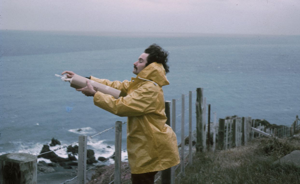 Dave Lowe taking an air flask sample at the edge of the Baring Head cliff in 1972. Photo: NIWA.