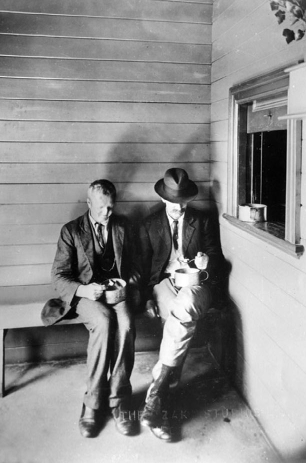 two men sit outside the soup kitchen