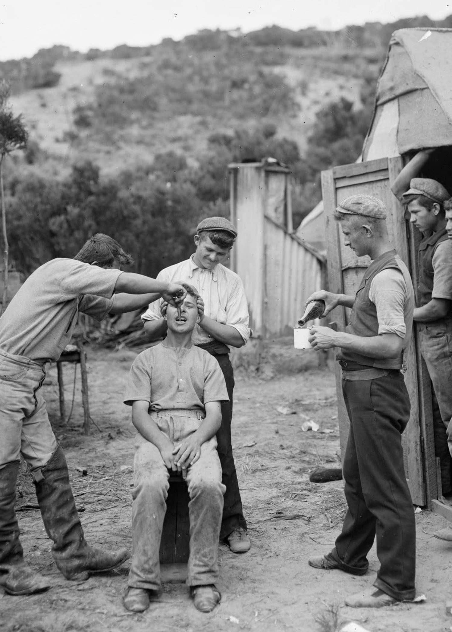 Child sits and gets a tooth pulled. Photo: Alexander Turnbull Library.