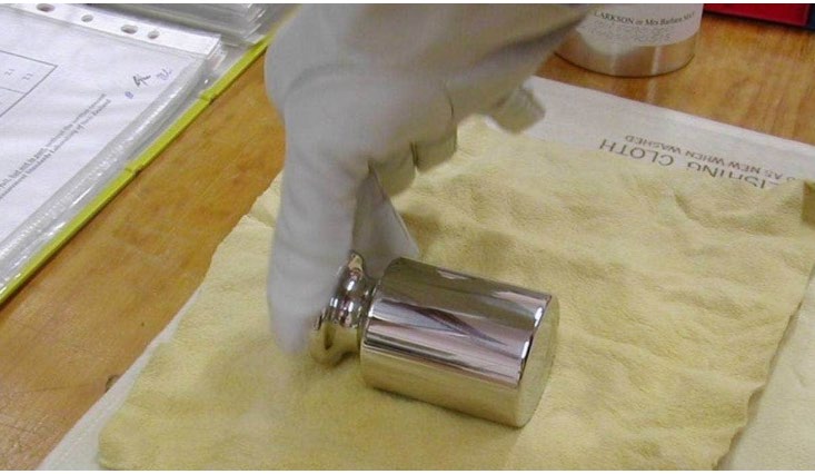 A metal transfer weight is carefully wrapped in a chamois before being flown to Paris for calibration